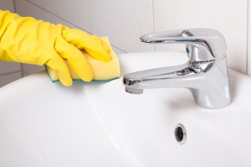 Professional cleaner disinfecting shared corridor surfaces